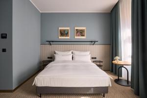 a bedroom with a large bed with white sheets at Entre Hotel by Zdrojowa in Wrocław