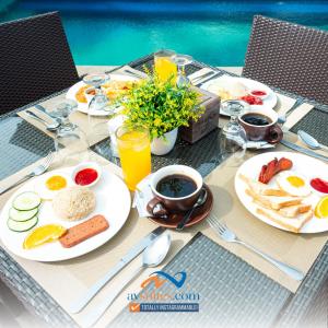 a table with plates of breakfast food on it at AV Suites in Puerto Galera