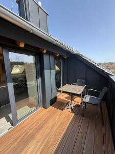 a wooden deck with a table and chairs on a house at Neues, stilvolles Loft inmitten der Weinberge 