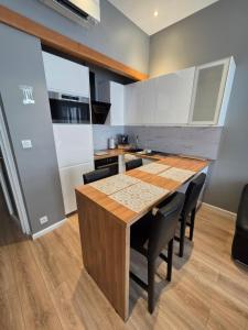 トゥールーズにあるAppartement Centre Carmesのキッチン(木製テーブル、黒い椅子付) +16枚の写真