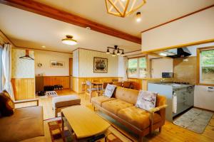 un salon avec un canapé et une cuisine dans l'établissement "Troll House" - a rental villa with natural hot sp - Vacation STAY 54186v, à To-katta