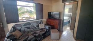 a bedroom with a bed and a tv and a window at Appartamento em ponta negra in Natal