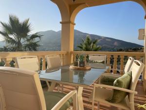 Una mesa y sillas en un balcón con vista. en Montaña Mimosa, en Alhaurín el Grande