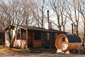 ein kleines Haus mit einem Fass daneben in der Unterkunft Kitakaruizawa Sweet Grass - Vacation STAY 82370v in Kita-karuizawa
