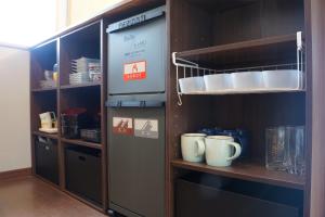 a kitchen with a shelf with cups and dishes at IG3 Oyado Sankan Shion - Vacation STAY 61821v in Ito