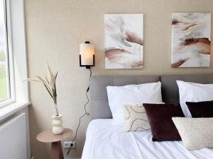 Ein Schlafzimmer mit einem Bett, einer Lampe und Gemälden an der Wand in der Unterkunft Private Room & Study-friendly, University Tilburg in Tilburg