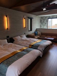 a room with three beds and a couch in it at DS2&3 - Vacation STAY 62512v in Tajiri