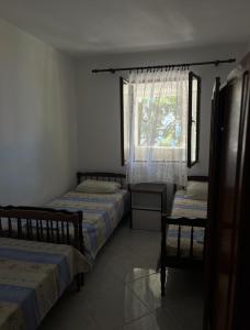 a bedroom with two beds and a window at Sutomore Ivana Ratac in Sutomore