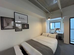 a bedroom with a bed with a love sign on the wall at MA Tower Nakasukawabata 7F - Vacation STAY 46005v in Fukuoka