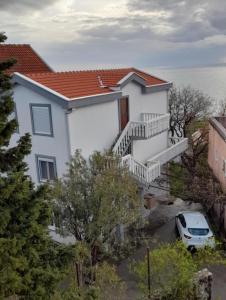 a white house with a car parked in front of it at Sutomore Ivana Ratac in Sutomore