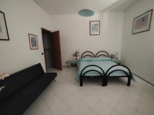 a bedroom with a bed and a couch at Alloggio per uso turistico Aldo Lo Presti in Campo di Carne