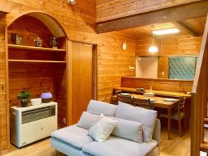 a living room with a couch and a table at Yatsugatake Villa FOREST&DOG - Vacation STAY 53545v in Hokuto