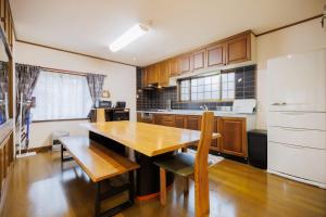 una cucina con tavolo in legno e armadi in legno di RINKA - Zao Sansuien - Gaia Resort - Vacation STAY 54030v a To-katta