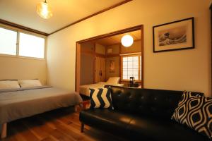 a bedroom with two beds and a couch and a mirror at Gyominsou - Vacation STAY 69053v in Otaru
