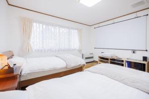una camera da letto con due letti e una finestra di RINKA - Zao Sansuien - Gaia Resort - Vacation STAY 54030v a To-katta