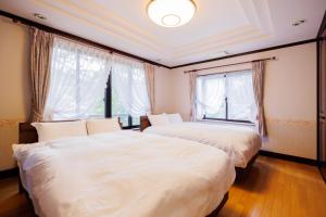 zwei Betten in einem Zimmer mit zwei Fenstern in der Unterkunft HIBIKI - Zao Sansuien Gaia Resort - Vacation STAY 54084v in To-katta + 31 Fotos