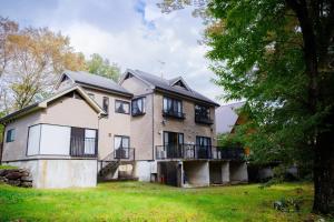 ein altes Haus auf einem Hügel mit einem Baum in der Unterkunft HIBIKI - Zao Sansuien Gaia Resort - Vacation STAY 54084v in To-katta