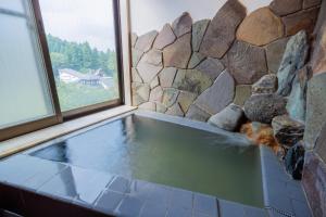 einen Pool mit Wasser in einem Zimmer mit Fenster in der Unterkunft Miyama - Zao Sansuien Gaia Resort - Vacation STAY 54108v in To-katta