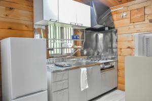 a kitchen with stainless steel appliances and wooden walls at 410 COZY INN - Rental villa with natural hot sprin - Vacation STAY 54148v in To-katta +6 photos