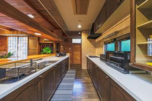 a large kitchen with wooden cabinets and stainless steel appliances at Zao Villa Suite Zen-ZEN - Vacation STAY 74899v in To-katta