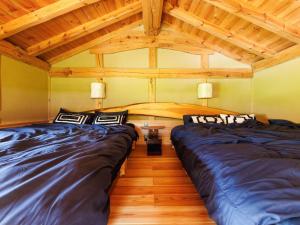 two beds in a room with wooden ceilings at Kakurega STAY Kurahinawara - Vacation STAY 74839v in Kyōmendao