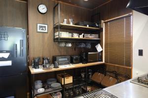 a kitchen with a refrigerator and a clock on the wall at Rental villa with natural hot spring "NEGURA" - Vacation STAY 54178v in To-katta