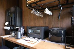 a desk with a computer and a microwave and a computericter at Rental villa with natural hot spring "NEGURA" - Vacation STAY 54178v in To-katta