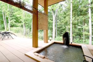 a hot tub in the middle of a patio with trees at Zao Gen -Zao Sansuien Gaia Resort - Vacation STAY 54130v in To-katta