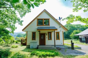 a small yellow and white house with a porch at Nonno, a rental villa with natural hot spring - Vacation STAY 54162v in To-katta