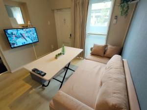 a living room with a couch and a table at MaMe Inn, - Vacation STAY 80189v in Saitama