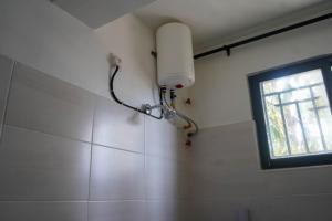 a light on the wall of a bathroom with a window at S&J Luxury Homes Mombasa in Mombasa +43 photos