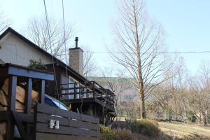 una casa con una recinzione di legno accanto a un albero di - F,J Forest Zao - Zao Sansuien - Gaia Resort - Vacation STAY 54193v a To-katta