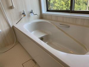 a white bath tub in a bathroom with a window at - Villa du Soleil - Zao Sansuien - Gaia Resort - Vacation STAY 54225v in To-katta
