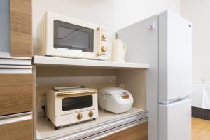 a kitchen with a microwave and a refrigerator at - Villa du Soleil - Zao Sansuien - Gaia Resort - Vacation STAY 54225v in To-katta +8 photos