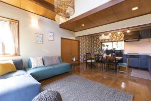 a living room with a blue couch and a kitchen at ZAO moco HOUSE - Vacation STAY 54233v in To-katta