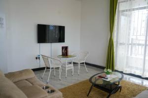 a living room with a couch and a table with chairs at S&J Luxury Homes Mombasa in Mombasa