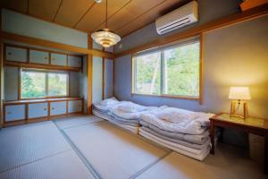 a room with a bed and two windows in it at Private cottage with wood stove [Senichi no Yado] - Vacation STAY 54169v in To-katta