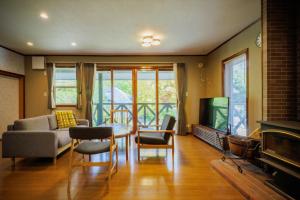 a living room with a couch a table and a tv at Private cottage with wood stove [Senichi no Yado] - Vacation STAY 54169v in To-katta