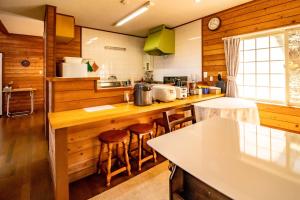 a kitchen with wooden walls and a counter with stools at Kattagun - House - Vacation STAY 17460 in To-katta