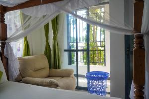 a bedroom with a chair in front of a window at S&J Luxury Homes Mombasa in Mombasa