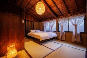 a bedroom with a bed in a room with windows at Muratamachi bukeyashiki- Gaia Resort - Vacation STAY 54893v in Murata