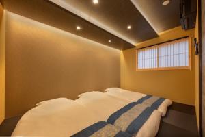 a bedroom with a bed in a room with a window at KYORAN-FUKITEI - Vacation STAY 57002v in Kyoto