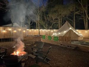 a campfire and a tent in a yard at night at Osoto Sauna & Glamping - Vacation STAY 91576v in Hokota