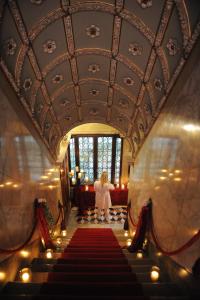 a woman is walking down a red carpeted stairs at Palazzetto Pisani Grand Canal in Venice