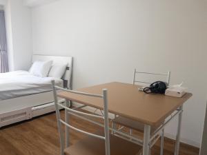 a room with a table and a bed and a table and chair at HARMONY HOTEL Urawa - Vacation STAY 18310 in Saitama