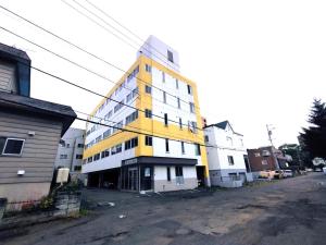 a yellow and white building on the side of a street at Meteoru Kitamaruyama - Vacation STAY 17560 in Sapporo