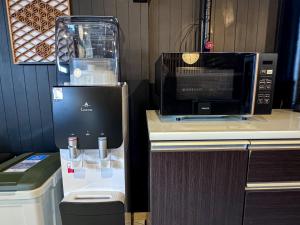 a microwave sitting on top of a counter next to a toilet at Machiyado Niko - Vacation STAY 83480v in Kusatsu