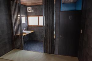 a bathroom with a sink and a mirror at Machiyado Niko - Vacation STAY 83480v in Kusatsu +3 photos