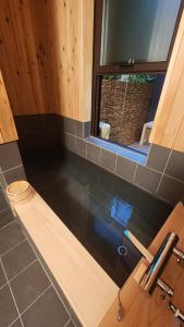 ein Badezimmer mit Badewanne und Fenster in der Unterkunft Hida Takayama Kandamachi House - Vacation STAY 88763v in Takayama + 38 Fotos