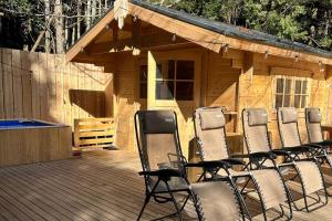 eine Gruppe von Stühlen auf einem Deck vor einer Kabine in der Unterkunft Osoto Sauna & Glamping - Vacation STAY 91574v in Hokota
